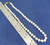 This necklace measures 18 inches in length, and has a gold plated clasp. The pearls are imitation (the fancy word is faux), and may have never been worn. The strand is knotted between each pearl, and the stringing material (either nylon or silk) is not soiled and is in excellent condition. The pearls measure 8 millimeters in diameter. Vintage, circa 1990.