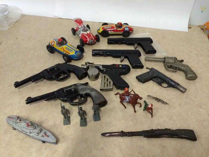 Tin Toys: Wyandotte pair of water gun pistols and pair of revolver style pistols.  Super Defense Gun complete. Lincoln Log Figures of Indians and soldiers. Barclay cast battleship with wheels.  Champion Friction Tin Litho racecars.  Fire Bird Indy-style racecar made in Japan.