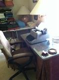 Glass top, draped table; office chair; manual typewriter