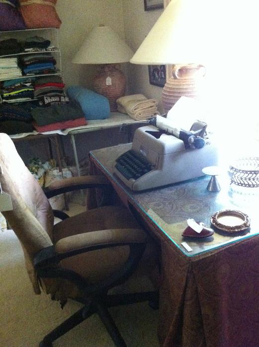 Glass top, draped table; office chair; manual typewriter