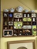 Wonderful wall display mishmash of old, small things. This one includes small tea pots, jewelry, and little animals.