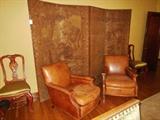 Vintage Down-Filled Glove-Leather Club Chairs in front of a 1920's Arts & Crafts Tapestry Four-Panel Screen and a pair of Vintage Red Chinoiserie Side Chairs