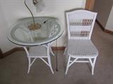 wicker glass top table and two chairs, only one shown.