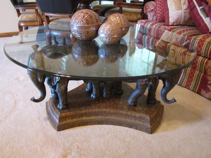 Unique carved elephants round glass top coffee table.