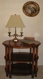 Drexel Oval Occasional Table with 2 Lower Shelves (28"W x 22"D x 24"H) shown with solid brass 2-arm style Table Lamp with Linen Shade and Antique Books