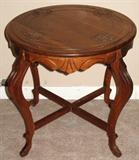 Country French Round Occasional Table with Carved Incised Design On Top and Apron with Crossed Stretchers and Cabriolet Legs
