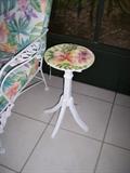 Sweet handpainted table matches the print in the white iron furniture.