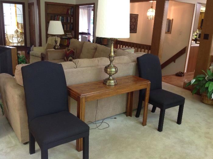 The other pair of black chairs and another sofa table and lamp
