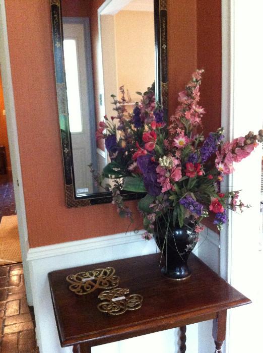 Small barley twist  table; brass trivets; floral arrangement; black/gold framed mirror