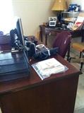 Corner table; desk; office chair; monitor; lamp; office supplies
