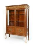Lot 1006:  FRENCH STYLE ORMOLU DISPLAY CABINET: 20th century production, mahogany veneer case with applied gilt ormolu decoration include floral trim, garland swag, and medallions. 2 glass and wood doors, illuminated interior with 2 Lexan shelves and single wood shelf. Glass sides, on 4 shaped feet. Measures 69 1/2'' h. x 48 1/2'' x 16 3/4''.