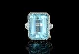 Lot 1041:  PLATINUM 40 CT AQUAMARINE AND DIAMOND RING: Platinum ring centers a stunning 40 Ct emerald cut aquamarine. Rated vslgB in hue, 2-3 tone, and 2-3 saturation. The aqua is flanked by 2 trapeze cut diamonds, the head and setting with 68 round brilliant cut diamonds. Approx. diamond weight is 1.93 Ctw, averaging VS in clarity and G color. Size 6.75 Mounting weight 13.3 grams. Sold with current Atlanta Gemological Laboratories GIA graduates 2010 appraisal for $20,000. Est. $15000/20000**