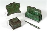Lot 1104:  4 PIECE TIFFANY PINE NEEDLE DESK SET: 4 pieces total, all marked Tiffany Studios New York, to include 1) #845, inkwell, missing insert, 3'' h. x 3 3/8'' x 3 3/8''. 2) #1019, letter holder, 5'' h. x 6 3/8'' x 3''. 3) #1003, pen holder, 4 3/8'' x 5''. 4) #968, letter opener, 7'' long.
CONDITION: Multiple condition issues, especially to #1 and #3. Please call for condition, sold as-is.