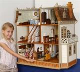 Lot 1339:  THE HOUSEWORKS VICTORIAN STYLE DOLL HOUSE: Second Empire Late Victorian Period family occupied home, fully furnished from the flag on the roof to the chicken in the yard. Plus box of additional pieces and family members. Mounted on swivel base. Overall 35 1/2''h. x 33'' x 25''.
CONDITION: Occasional loose piece of trim and wall paper. Sold as is, in lightly played with condition.