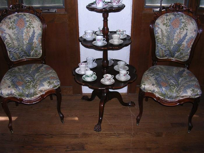 Carved chairs, tea table with demitasse cups.