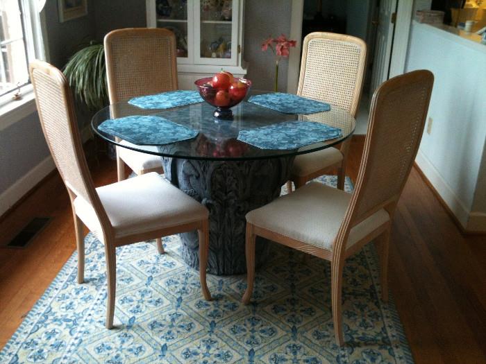 Very nice round breakfast table w/ a light blue concrete base & glass top, 4 cane-back dining chairs, blue & white rug