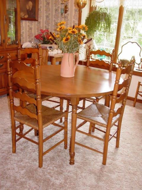 Round maple dining room table with four leaves plus six ladder back dining room chairs.