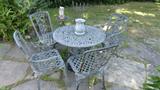 patio tabl and chiars, lots of plants and potsold bird bath, bird houses