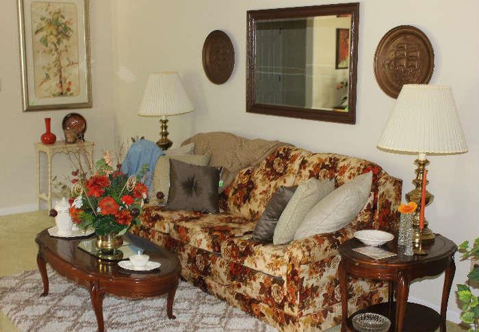 View of couch with end tables, lamps, coffee table and antique beveled mirror.