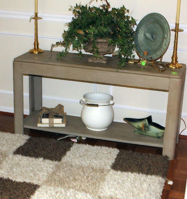 Closer look of items on sofa table with French Chamber Pot. Beige and brown area rug.