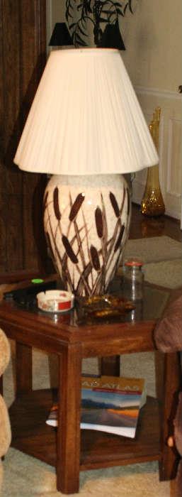One of the glass top end tables with wheat lamp with bottom shelf in the den. 