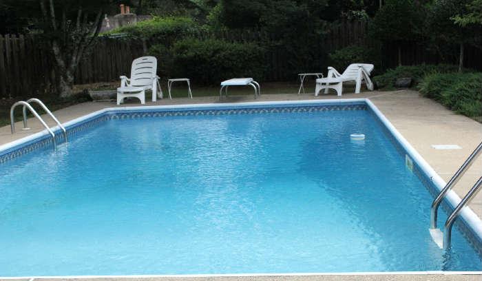 Close view of the swimming pool and chairs.  Beautiful landscaped back yard.