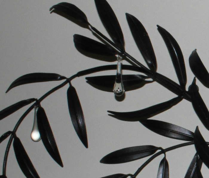 Close-up of metal wall hanging with tear drop crystals.