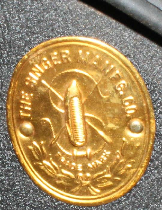 The gold seal on the old Singer sewing machine.