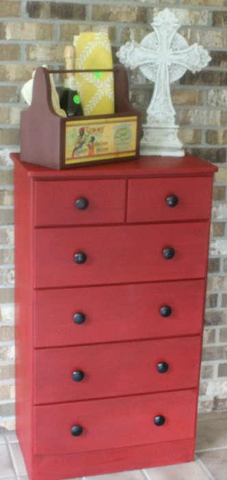 Red painted chest with black knobs.