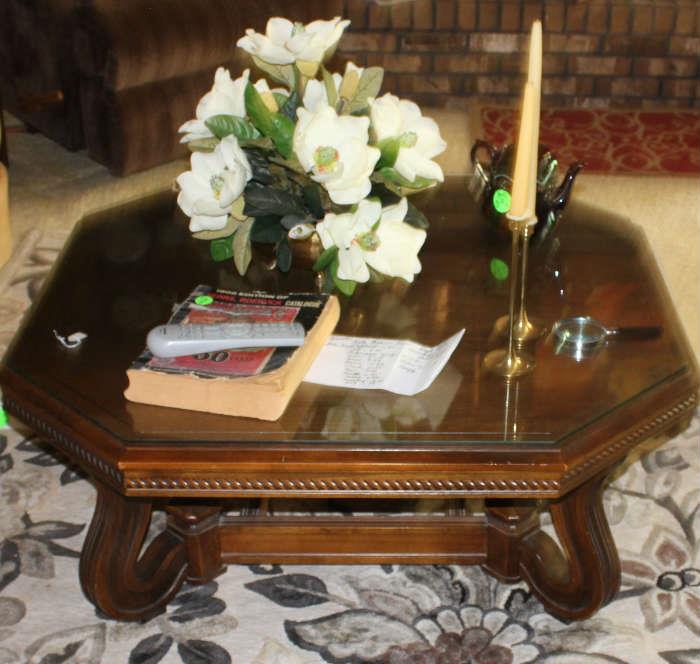 Beautiful coffee table with glass top in den. Has old Sears catalog and flower arrangement. 