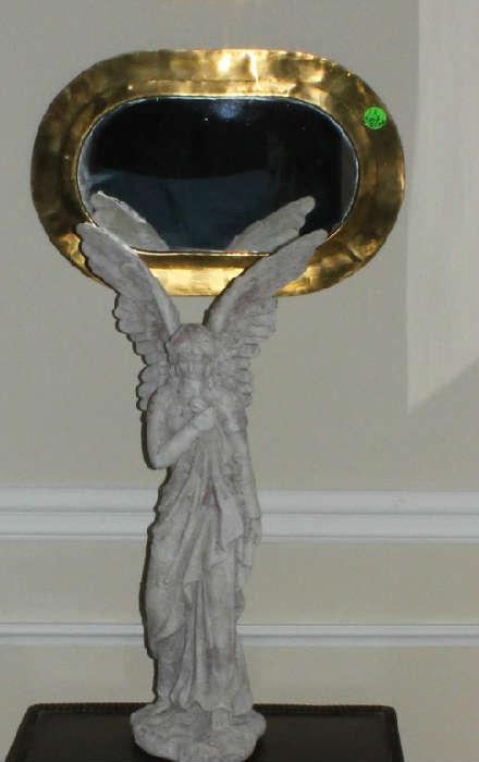 A tall angel that stands in front of just one of the 3 copper mirrors in dining room.