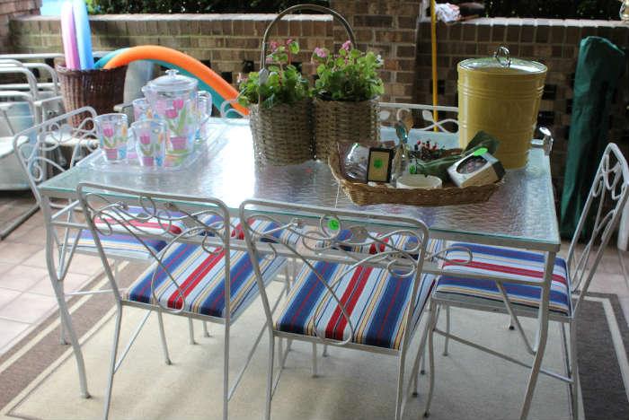 A better view of the glass top white metal table  with new cushions on chairs and accessories ready for the pool.