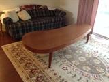 Oversize teakwood coffee table shown with sleeper sofa and area rug