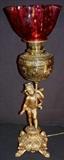 273 - Victorian cupid lamp with cranberry shade, oil lamp converted to electric, 26.5IN 'T
