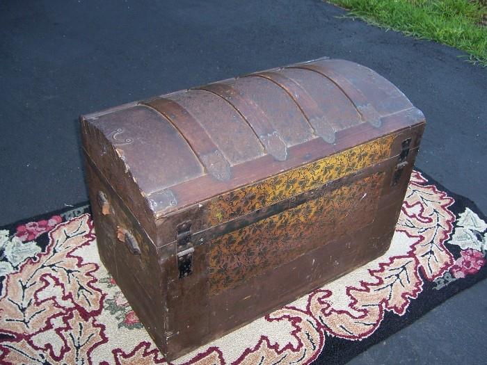 Antique Wooden chest is cover with an exterior decoration of metal filigree, brass corners,  metal lock intact.