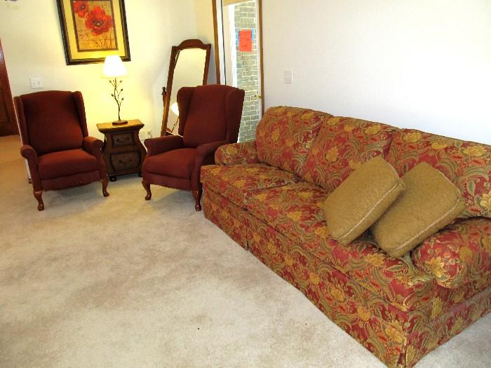 Elegant Thomasville Sleeper Sofa with rolled arms,  red and gold floral tapestry style upholstery; Pair of Matching LazyBoy Wingback Style Recliners with Queen Anne Style legs, Wine Colored upholstery; Unique End Table with 2 drawers storage, Side magazine or what not storage, retro style; Also shown is a Tilt Style Dressing Mirror with Wood frame stand and pecan finish, beveled mirror; Accent Table Lamp & Artwork shown are also available.