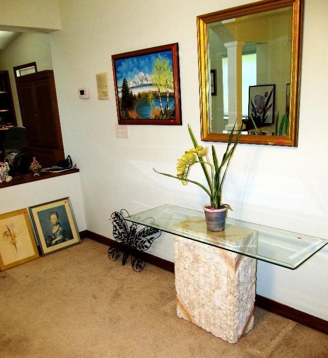 Stone and Glass Foyer / Sofa Table with beveled glass top and stone base.  Also shown is a large beveled mirror with gilt frame...one of several mirrors available in this sale; Also shown are some of the artworks available in this sale...original oil paintings, good prints...listed artists, also shown is a very well done metal sculpture of a butterfly.