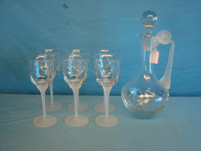 French crystal decanter set, with six wine goblets; Clear and frost styling. Decanter stands 13" tall, goblets stand 8" tall. Goblets are in excellent condition, no chips or cracks, decanter has some light wear from stopper.