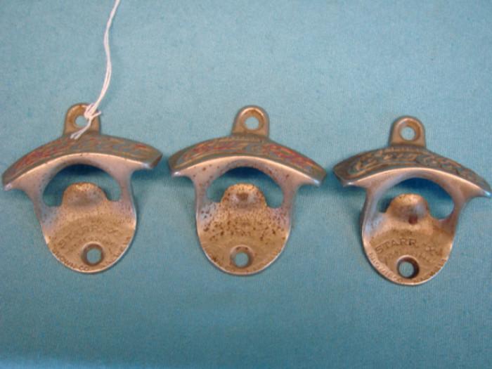 Three very nice Starr "X" Brown Company wall-mounted bottle openers; All three are Coca-Cola. Most of the paint is worn off, each has some other light wear, oxidation, wear from use. Each measures 3 1/2" long.