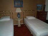 Twin Beds With Brass Headboards, Small Chest, There Are 2 Tables Like The One Shown