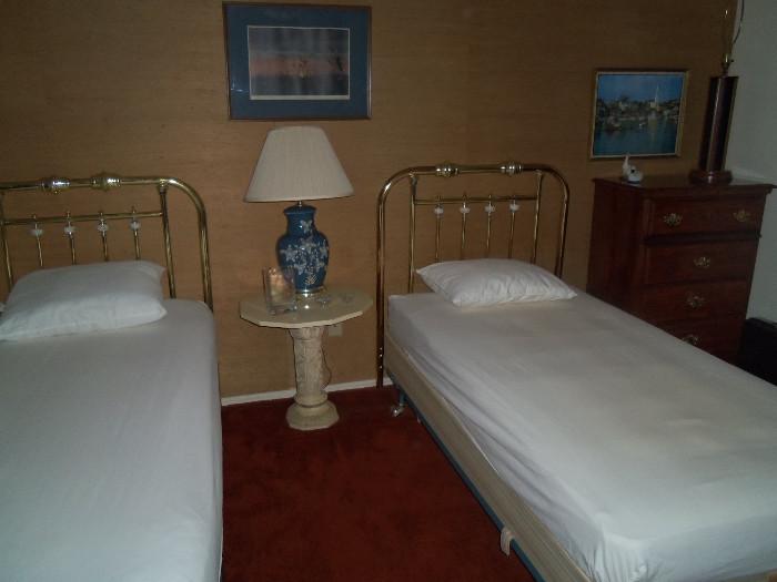 Twin Beds With Brass Headboards, Small Chest, There Are 2 Tables Like The One Shown