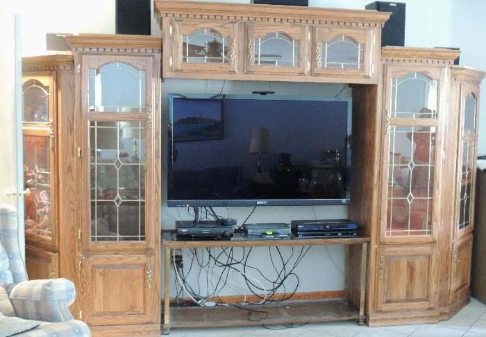 5 piece lighted modular wall unit/entertainment center. (Please note, the TV is shown on a separate console table, which is not a part of the unit itself). The unit consists of two corner cabinets, which can be used independently, two tall cabinets, and the bridge unit on top. 