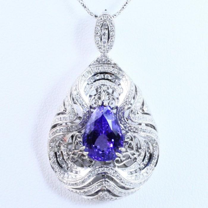 New 14K white gold diamond & tanzanite necklace with a ~6.82 ct pear modified brilliant tanzanite & ~1.22 ctw in round brilliant diamonds (SI2 to SI3 clarity, G to H color): 1 3/4" pendant, 18" chain, 16.2 gms gross weight. Certified in 2014 by E.G.L. U.S.A. Appraised in 2012 by U.G.S. (Universal Gemological Services) for $13,990.
