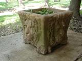 Very large planter with lion faces on all sides.