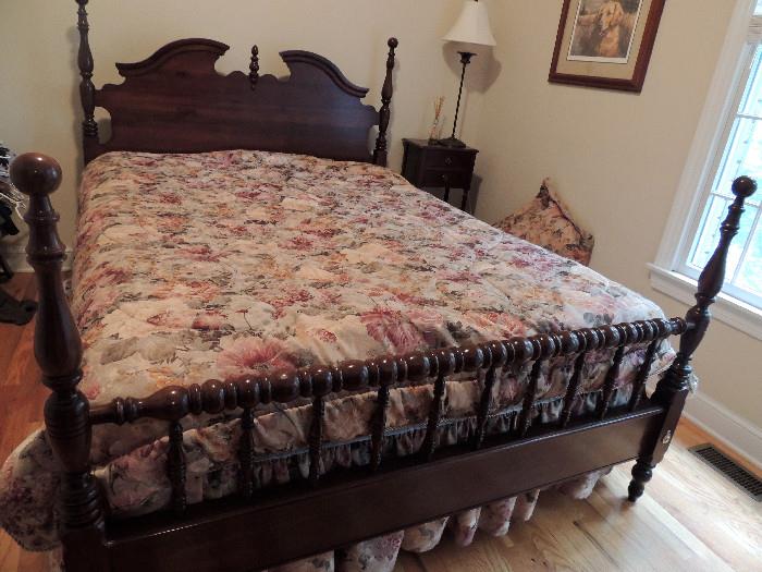 Bed with spool-turned footboard and open pediment headboard and low posts.