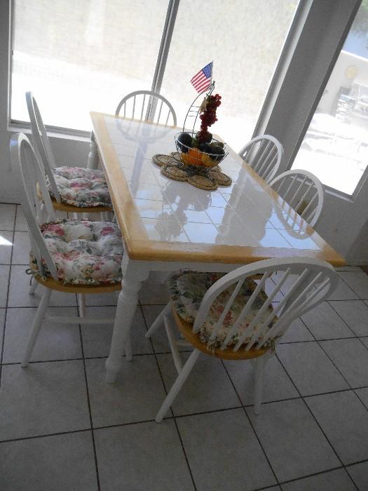 Tile-topped kitchen table and 6 white chairs. The cushions can be changed out.