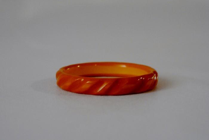 Bakelite Bangle - Yellow Bakelite bangle with carved detailing depicting a curved striped motif
