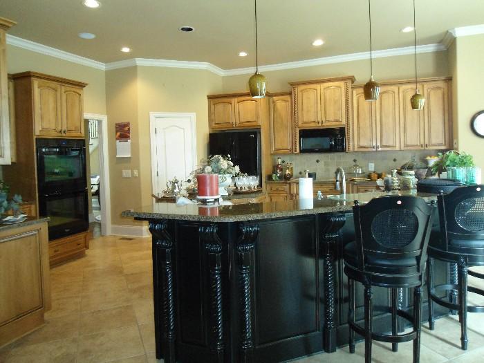Overview of the kitchen area w/items for sale on granite countertops.
