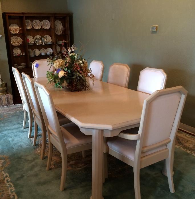 1980's huge white table with 8 chairs and 2 leaves atop a beautiful room size rug.