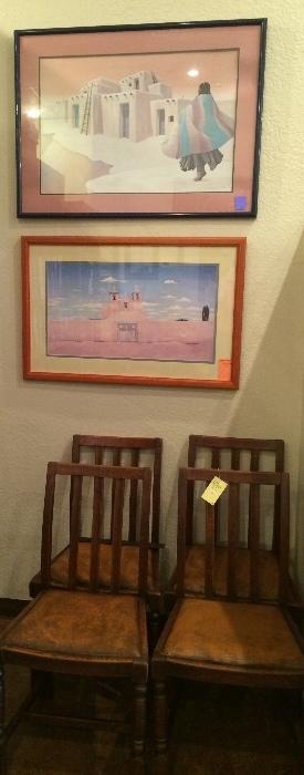 Four vintage oak chairs with leather seats and Southwestern art.